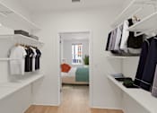 Thumbnail 38 of 66 - A walk in closet with clothes hanging on shelves.