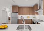 Thumbnail 37 of 66 - A modern kitchen with a stainless steel sink and wooden cabinets.