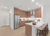Thumbnail 31 of 66 - A modern kitchen with a white island and wooden cabinets.