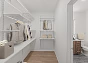 Thumbnail 25 of 66 - A white bathroom with a toilet, sink, and a walk-in closet.