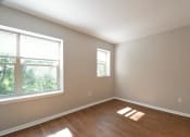 Thumbnail 7 of 27 - an empty bedroom with a large window and hardwood floors
