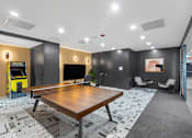 Thumbnail 56 of 66 - A room with a ping pong table and a foosball table.