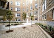 Thumbnail 14 of 22 - a courtyard with trees and a brick building