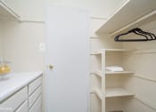 Thumbnail 8 of 14 - a walk in closet with white cabinets and a white door