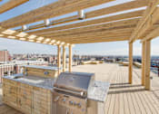 Thumbnail 8 of 17 - a rooftop deck with a barbecue and a view of the city at 1841 Columbia Road Apartments, Washington