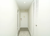 Thumbnail 9 of 14 - a hallway with a white door and white walls