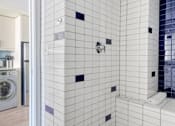 Thumbnail 11 of 17 - a white and blue bathroom with a washer and dryer