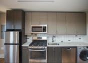 Thumbnail 3 of 19 - a kitchen with stainless steel appliances and wooden cabinets