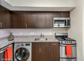 Thumbnail 17 of 27 - a kitchen with wooden cabinets and stainless steel appliances