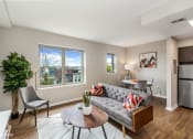 Thumbnail 3 of 27 - a living room with a couch and a table in front of a window