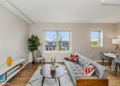 Thumbnail 11 of 27 - a living room with a couch and a coffee table in front of a window