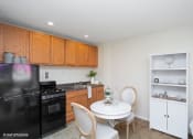 Thumbnail 5 of 14 - a kitchen with black appliances and a white table and chairs
