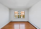 Thumbnail 6 of 16 - an empty room with a large window and wooden floors