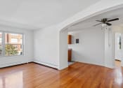 Thumbnail 2 of 16 - an empty living room with wood floors and a ceiling fan