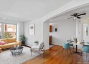Thumbnail 1 of 16 - a living room with a couch and a table and a window