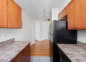 Thumbnail 11 of 16 - a kitchen with granite counter tops and a black refrigerator