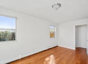 Thumbnail 8 of 16 - an empty living room with wood flooring and a door to a bedroom
