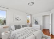 Thumbnail 7 of 16 - a white bedroom with a bed and two windows