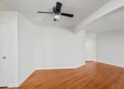 Thumbnail 4 of 16 - an empty living room with wood floors and a ceiling fan