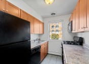Thumbnail 10 of 16 - a kitchen with black appliances and wooden cabinets