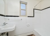 Thumbnail 12 of 16 - a bathroom with a sink and a tub and a window