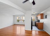 Thumbnail 3 of 16 - an empty living room and kitchen with wood floors and a window