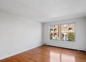 Thumbnail 5 of 16 - an empty living room with a large window and wooden floors