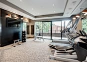 Thumbnail 10 of 16 - A gym with treadmills, weights, and a television at Coda on H Apartments, District of Columbia 20002