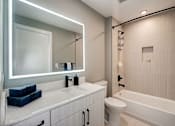 Thumbnail 11 of 16 - a bathroom with a toilet and a sink and a mirror at Coda on H Apartments, Washington, DC 20002