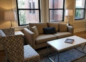 Thumbnail 8 of 19 - a living room with a couch coffee table and a refrigerator