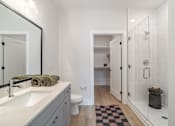 Thumbnail 14 of 47 - Modern bathroom with walk in shower and vanity at The Yancey Apartments, Charlotte, 28217