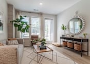 Thumbnail 1 of 47 - Bright living room with neutral decor and greenery at The Yancey Apartments, North Carolina