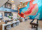 Thumbnail 2 of 47 - Vibrant clubhouse lounge with colorful abstract wall mural at The Yancey Apartments, North Carolina, 28217