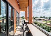 Thumbnail 11 of 47 - Covered balcony seating with panoramic city views at The Yancey Apartments, Charlotte, NC 28217