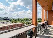Thumbnail 7 of 47 - Rooftop balcony with bar height seating and skyline views at The Yancey Apartments, Charlotte, NC 28217