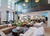 Thumbnail 5 of 47 - Double height clubhouse with lounge seating and kitchen at The Yancey Apartments, Charlotte, 28217