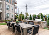 Thumbnail 40 of 47 - Outdoor dining patio with builtin grills and seating at The Yancey Apartments, North Carolina, 28217