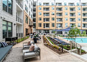 Thumbnail 41 of 47 - Courtyard with pool lounge seating and landscaped gardens at The Yancey Apartments, Charlotte, NC