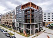 Thumbnail 26 of 47 - Modern apartment complex with orange accent framing and balconies at The Yancey Apartments, Charlotte, North Carolina