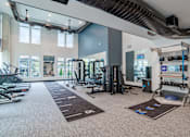 Thumbnail 28 of 47 - Fitness center with cardio machines and functional training area at The Yancey Apartments, Charlotte, NC 28217