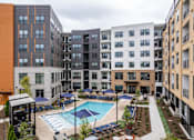 Thumbnail 22 of 47 - Courtyard pool area surrounded by modern apartment buildings at The Yancey Apartments, Charlotte, North Carolina