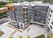 Thumbnail 23 of 47 - Aerial view of modern apartment courtyard with gray facade at The Yancey Apartments, Charlotte, NC 28217
