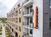 Thumbnail 27 of 47 - Modern apartment exterior with vertical branded signage at The Yancey Apartments, Charlotte, 28217