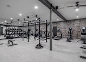 Thumbnail 16 of 30 - A well-equipped gym with various exercise machines and weights.