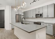 Thumbnail 26 of 30 - A kitchen with a large island and modern appliances at Vintage Edge Nashville Apartments, Nashville, TN, 37211