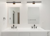 Thumbnail 29 of 30 - A white bathroom with two sinks and a mirror above each at Vintage Edge Nashville Apartments, Nashville