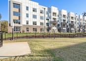 Thumbnail 36 of 41 - A large white building with a black fence in front of it at Vintage Raleigh West Apartments, Raleigh, North Carolina