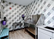 Thumbnail 11 of 30 - A kitchen with a white tile wall and a stainless steel sink.