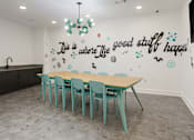 Thumbnail 9 of 30 - A conference room with a long table and chairs and a quote on the wall.