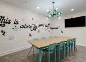 Thumbnail 10 of 30 - A room with a long table and chairs and a quote on the wall.